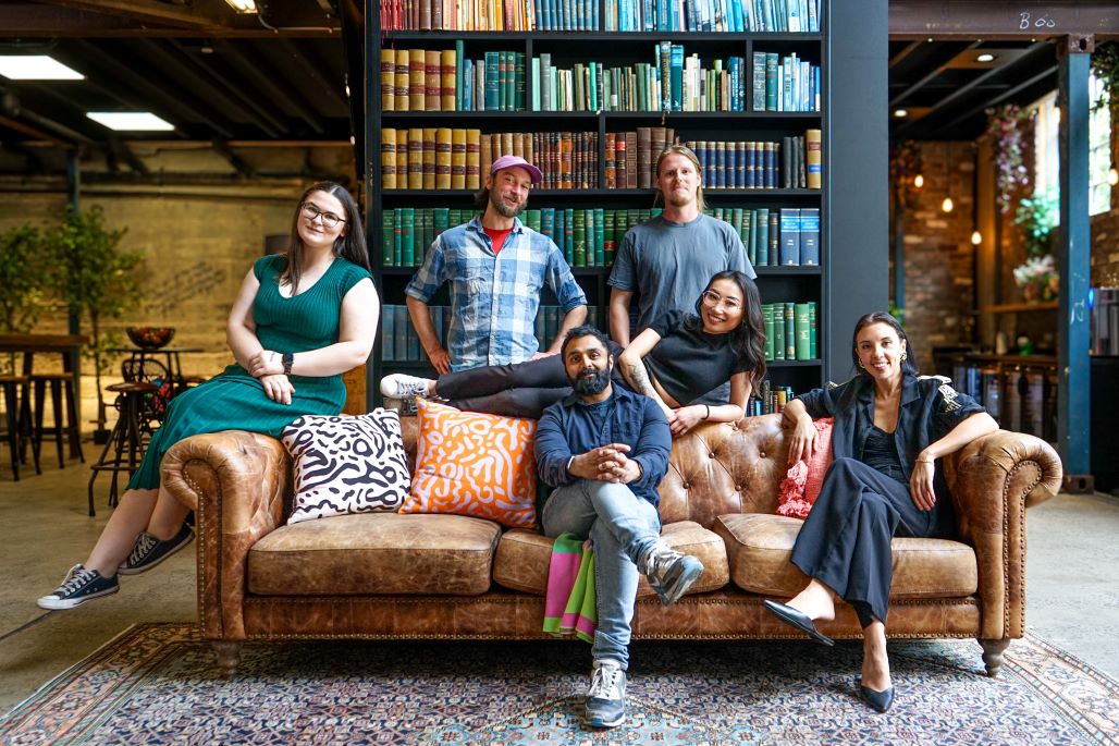 Work Inc team sitting on a couch for group photo.